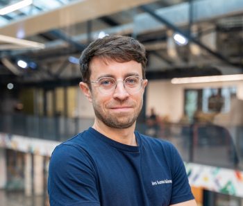 Portrait professionnel d'un homme avec lunettes dans un bureau moderne et lumineux